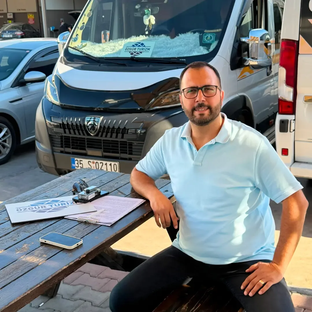Özgür Turizm yetkilisi araçlarının önünde